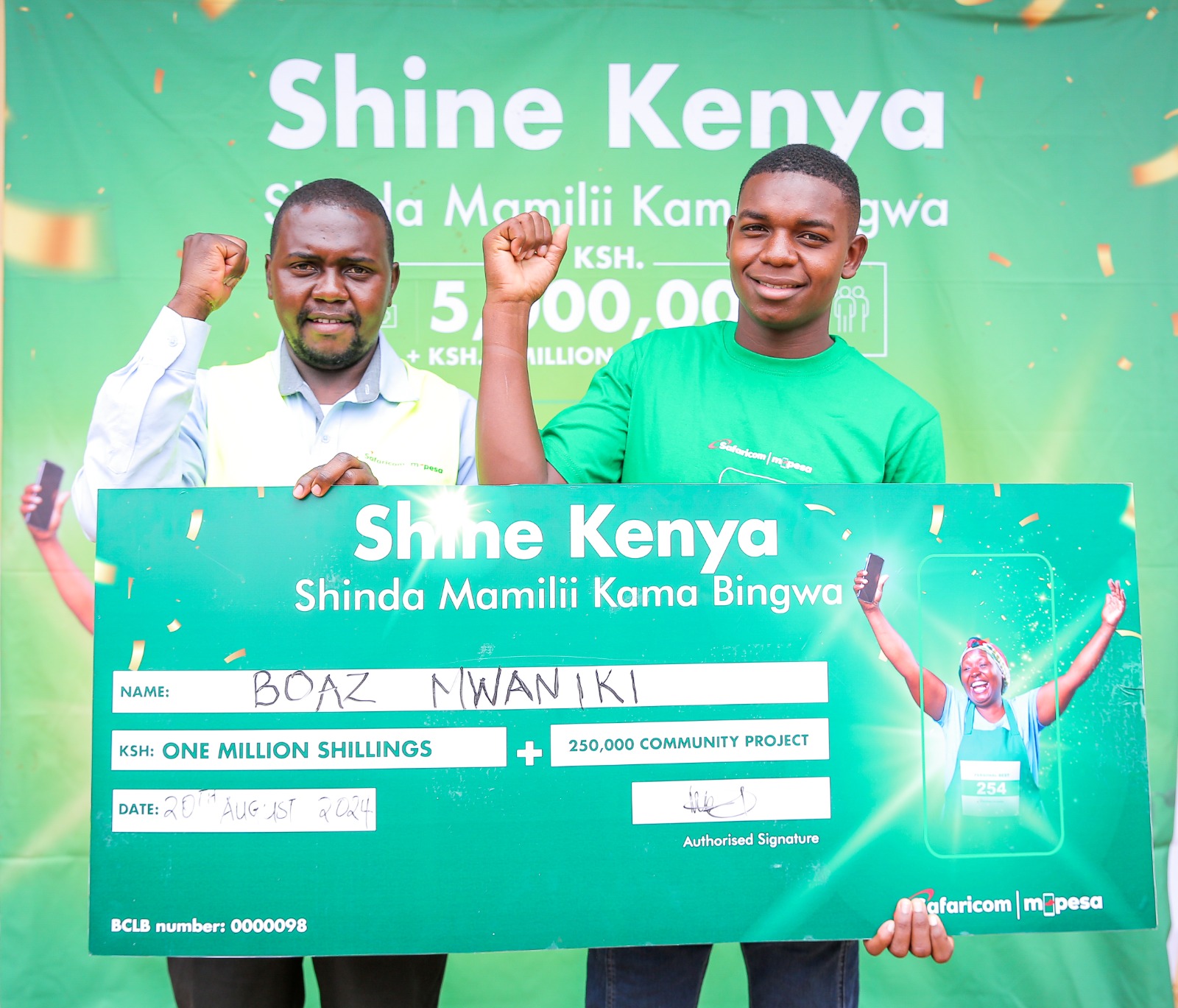 Cosmus Maluki -Trade Development Representative Mwingi North at Safaricom (Left) handing over a dummy check to Boaz Mwaniki, winner of Ksh.1 million during the Shine Kenya Shinda Mamilii Kama Bingwa award ceremony held at Migwani in Kitui County.