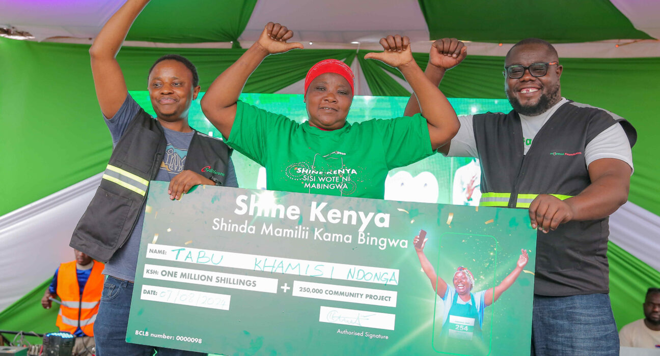Martin Mugera, Marketing Manager at Safaricom(Left) and Cosmas Albert, Territory Business Lead at Safaricom, Kilifi (Right) handing over Sh. 1 Milion dummy cheque to Tabu Khamisi Ndonga at the awards ceremony of Shine Kenya Shinda Mamili kama Bingwa Campaign held at Mtwapa in Kilifi County
