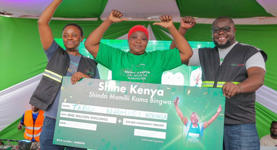 Martin Mugera, Marketing Manager at Safaricom(Left) and Cosmas Albert, Territory Business Lead at Safaricom, Kilifi (Right) handing over Sh. 1 Milion dummy cheque to Tabu Khamisi Ndonga at the awards ceremony of Shine Kenya Shinda Mamili kama Bingwa Campaign held at Mtwapa in Kilifi County