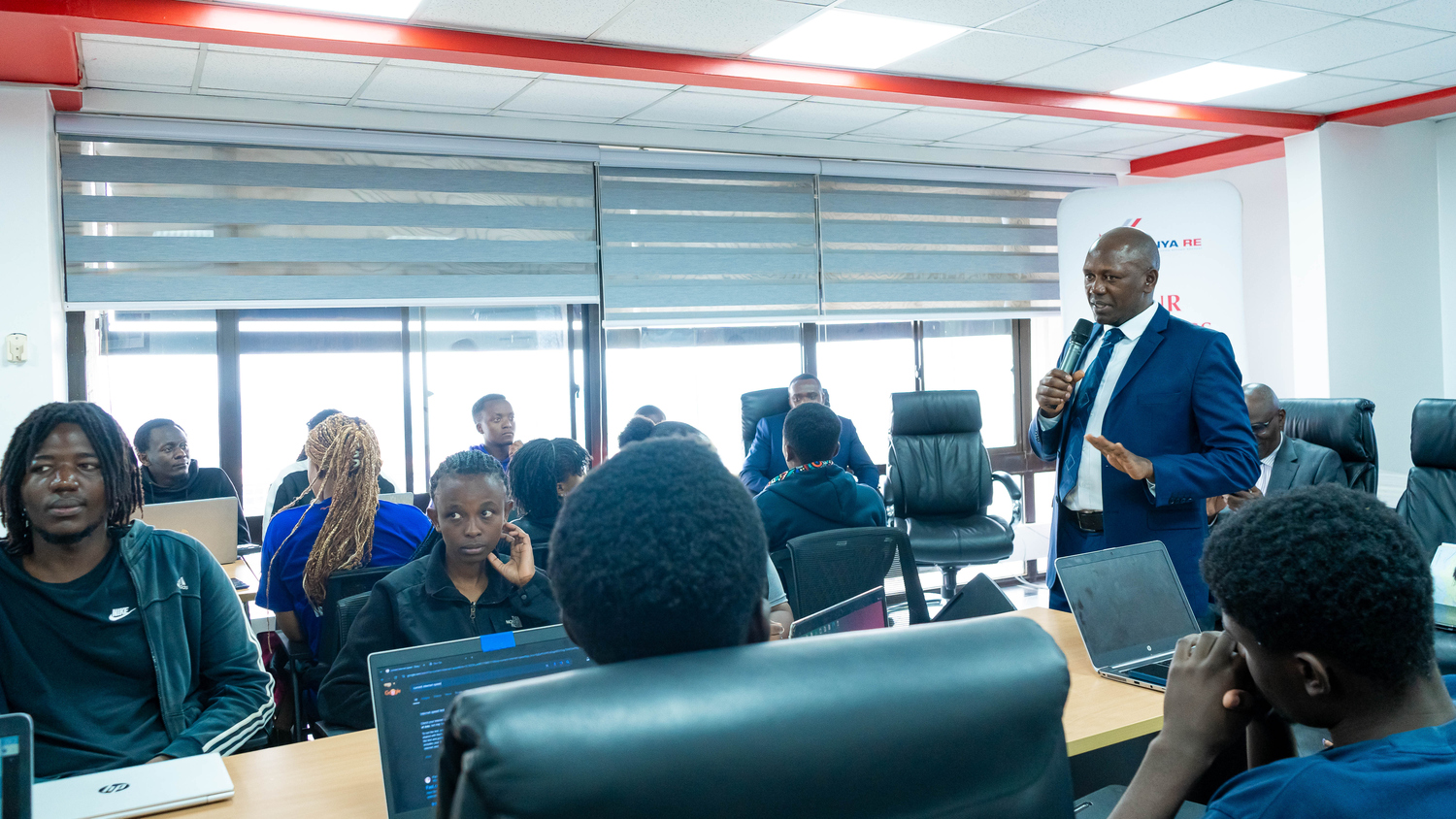 Kenya Re Managing Director, Dr. Hillary Wachinga, addresses university students during the launch of the inaugural Kenya Re Artificial Intelligence for Insurance (AI4I) hackathon.