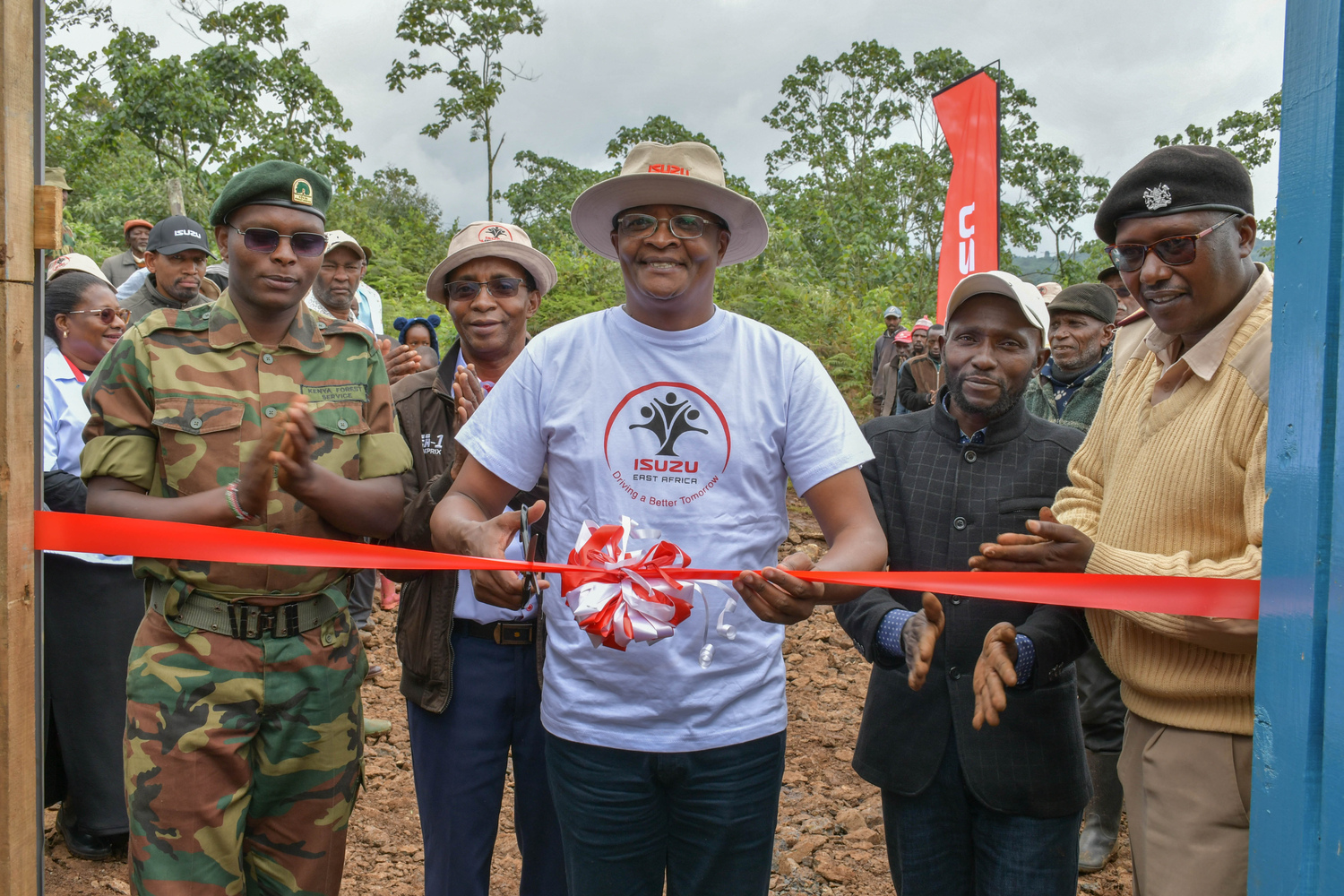 Isuzu EA Foundation Director Charles Kariuki unveils the plaque during the handover ceremony of the newly established tree nursery to the Kiamuturi community by Isuzu EA. The nursery which accommodates 13 beds, will grow 52,000 seedlings annually, focusing on increasing indigenous and fruit tree seedlings.