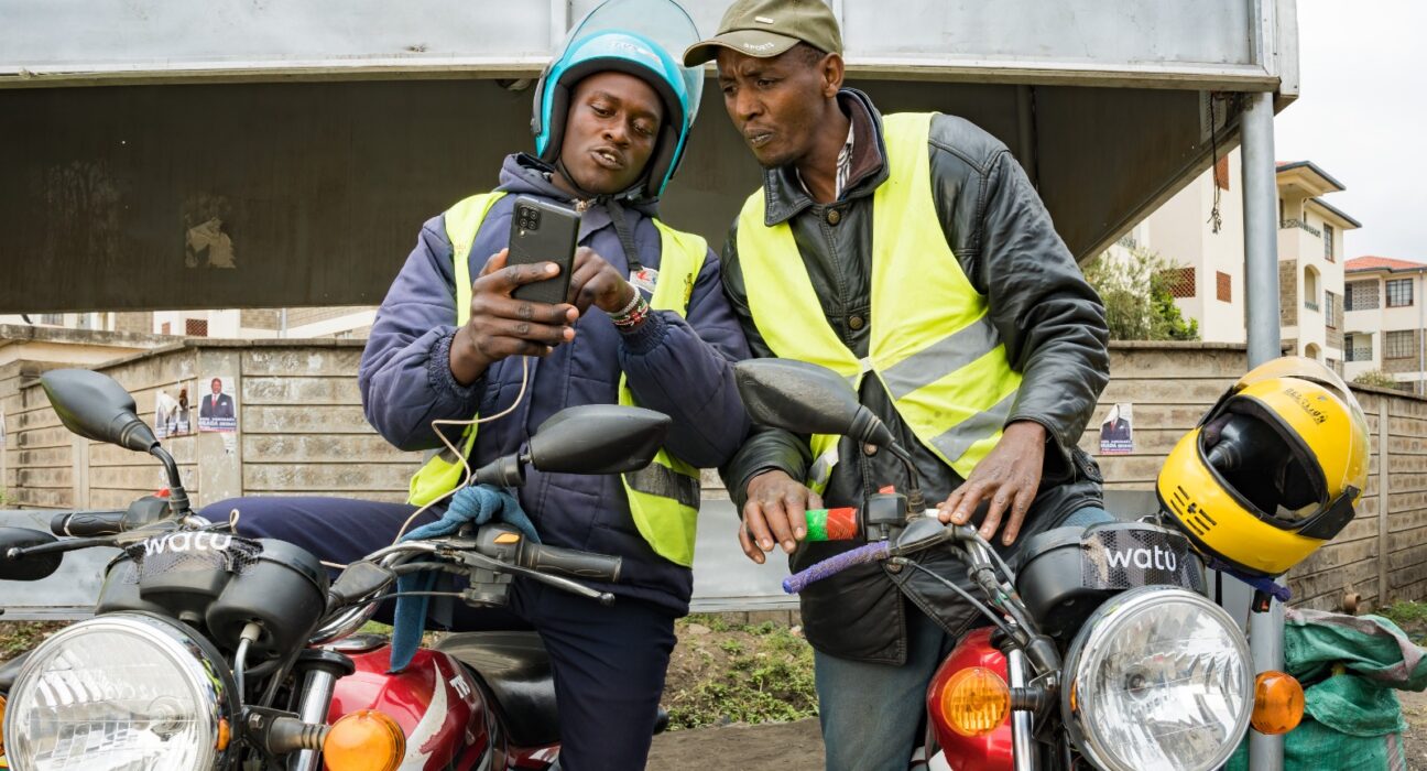 Boda Boda riders reviewing some operating features on a smartphone