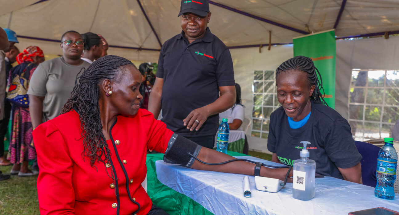 Gunilla Ouko (left), Regional Business lead, Greater Western Region, checking her blood pressure during a M-PESA Foundation medical camp in Vihiga County.