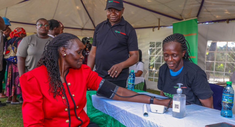 Gunilla Ouko (left), Regional Business lead, Greater Western Region, checking her blood pressure during a M-PESA Foundation medical camp in Vihiga County.