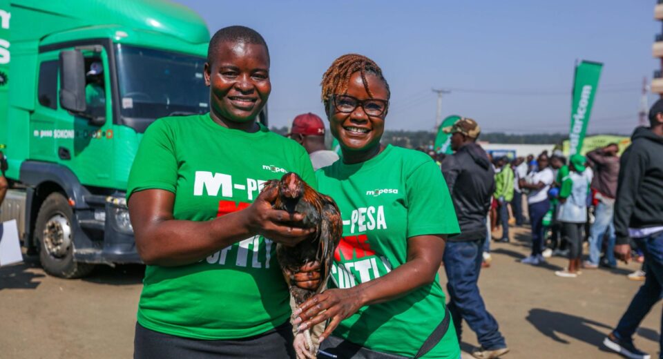 Zizwe Awuor, Director of Brand and Marketing, Safaricom PLC awarding Lavender Atieno a chicken during the official M-PESA SOKONI Greater Western Edition at Migori County.