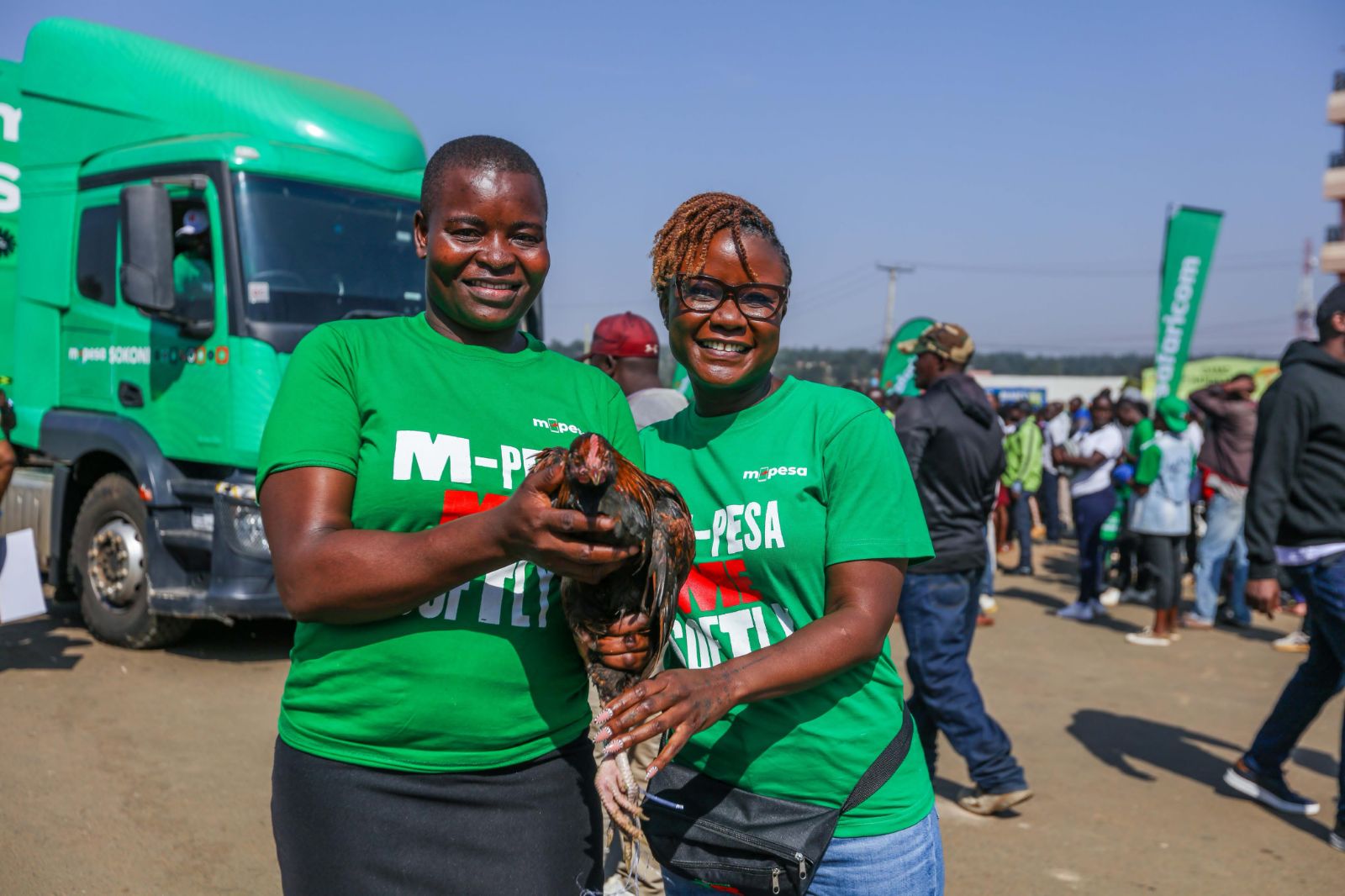 Zizwe Awuor, Director of Brand and Marketing, Safaricom PLC awarding Lavender Atieno a chicken during the official M-PESA SOKONI Greater Western Edition at Migori County.