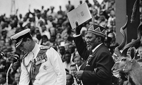 Kenyan former leader Jomo Kenyatta pictured with the official document of independence in Nairobi on 13 December 1963