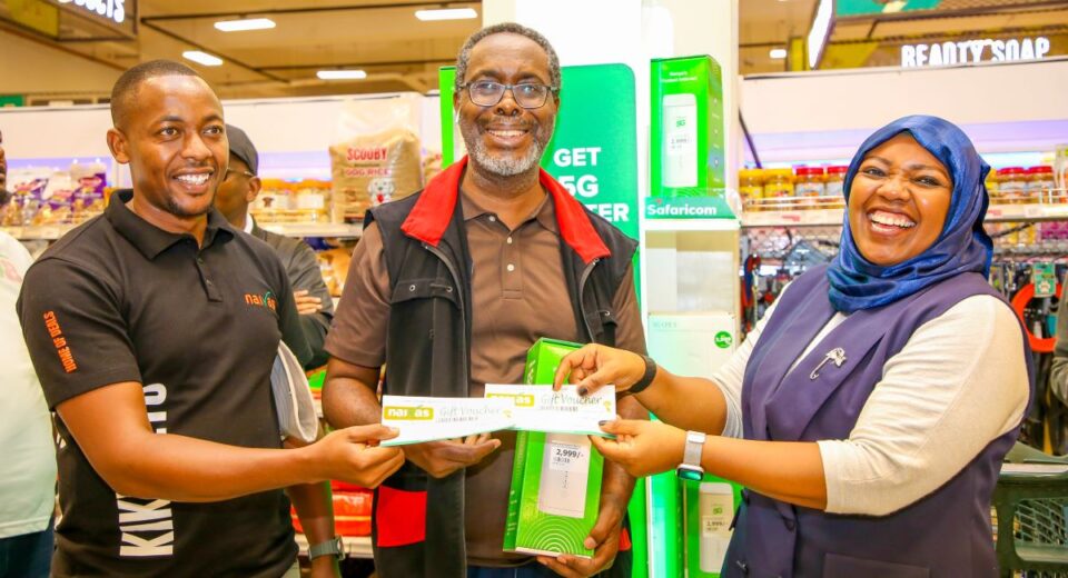 Fawzia Ali, Chief Consumer Business Officer at Safaricom PLC (Right) awards customer Afurika Juvenal with Naivas shopping vouchers after he purchased a Safaricom 5G router. Assisting in the presentation is Dennis Makori, Senior Commercial Manager at Naivas Supermarket. The award was presented during the 5G partnership launch between Safaricom and Naivas Supermarket held at the Imara Imara Mall in Nairobi.