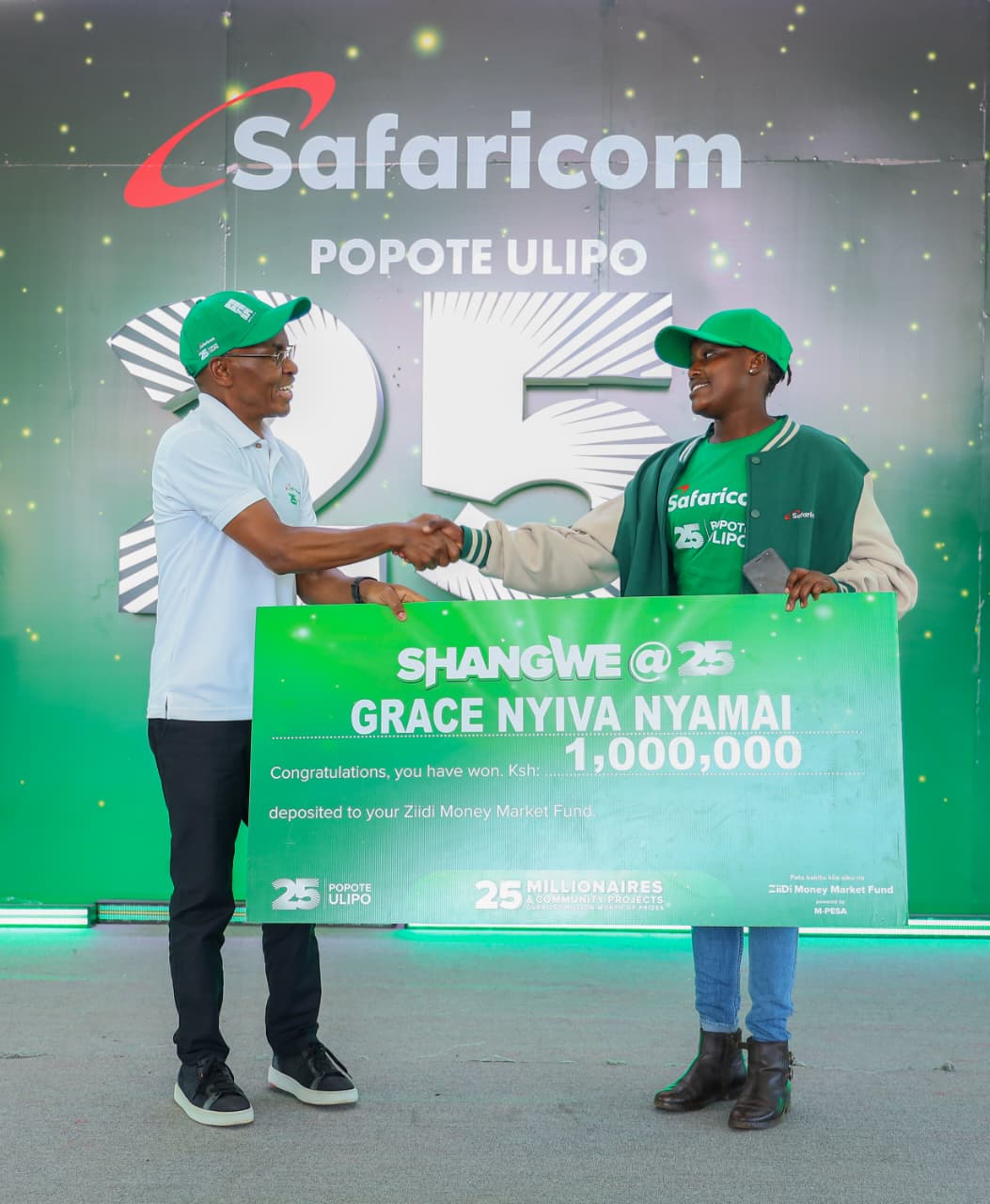Safaricom CEO Peter Ndegwa (left) presents a Ksh. 1 Million cheque to Grace Nyiva Nyamai (right) during the Shangwe @25 award ceremony held at Kungondo Road Market in Nairobi.