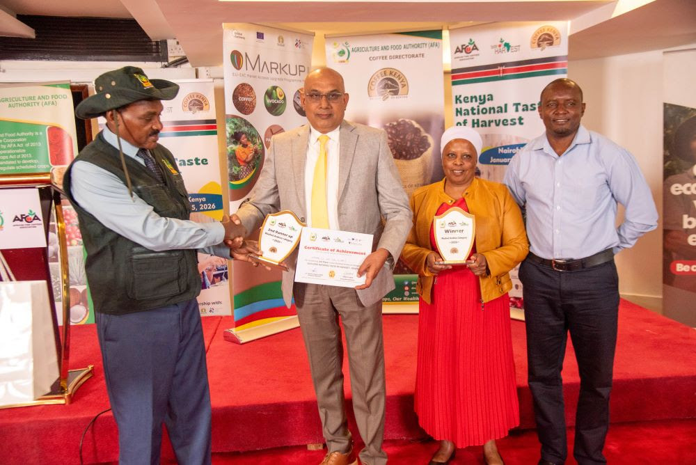 From left: Mr. James Wanjohi, Director in charge of State Corporations, presents the 1st and 3rd Place awards in the Washed Arabica Category to John Sathya, CEO, Tatu Coffee Estates Limited; Faith Karimi, General Manager, Oaklands Coffee Marketing Limited; and Simon Nyamu, Chief Liquorer, Tatu Coffee Estates Limited, during the National Taste of Harvest Kenya 2025–2026.