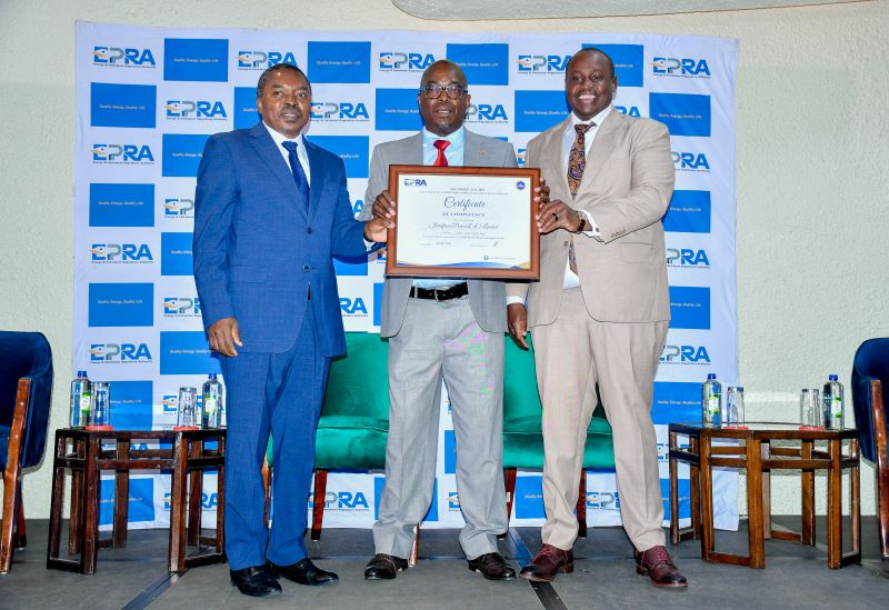 Eng Isaac Kiva, Secretary for Renewable Energy (MOEP) and Daniel Kiptoo, EPRA's Director General present a certificate of compliance on Energy Management to the Chief Financial Officer Iberaafrica Power (E.A) LTD, Michael Nyangi .